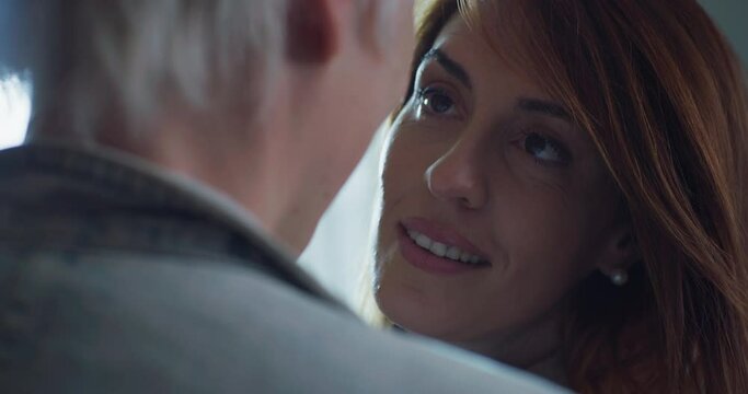Cinematic shot of carefree happy homosexual female gay and transgender man couple in love is enjoying time together is hugging and kissing with affection as sign of timeless forever love at home.