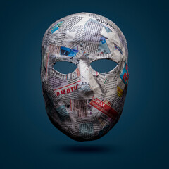 Papier mache mask. The face of the mask is pasted over with newspaper clippings.