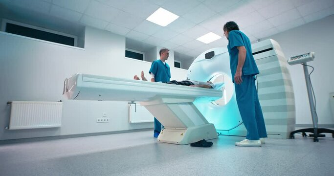 Mature doctors finishing CT scanning of senior man