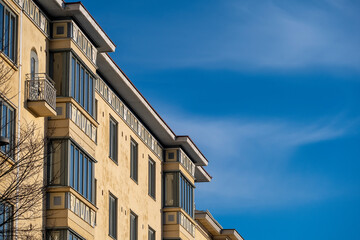 A closeup of an old european style residential building exterior against bright blue sky.