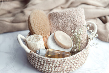 Fototapeta na wymiar woven basket with natural body care products - sponge, towel, loofah, soap, body brush