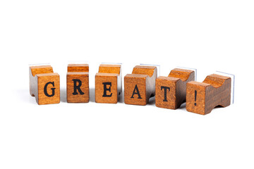 Word Great! Small wooden moveable type rubber stamp font letters isolated on white background....
