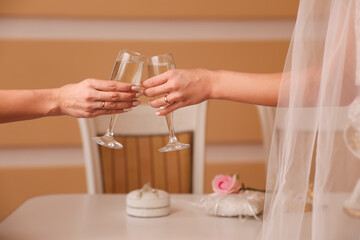 Two glasses with sparkling champagne in hands, holiday concept, wedding