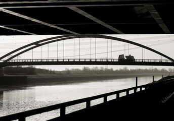 Blick auf eine Bogenbrücke von einem Standpunkt unterhalb einer Autobahnbrücke in Magdeburg