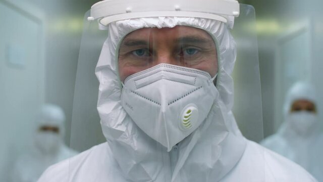 Portrait Of Male Hospital Worker In Protective Uniform, Face Shield And Mask Posing For Camera While Working In Time Of Covid-19 Pandemic