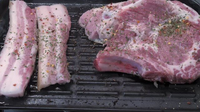 Juicy pice of fresh meat with bacon prepared on grill with spices.