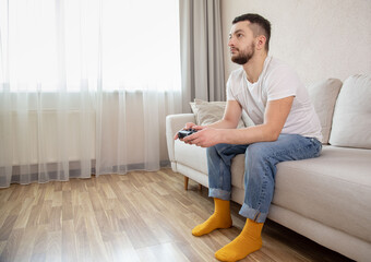 hipster man holding joystick while playing computer games. Computer games concept. Guy sitting on...