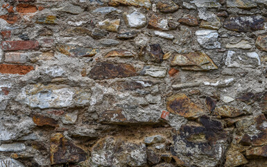 The wall is made of different stones. Stone background.