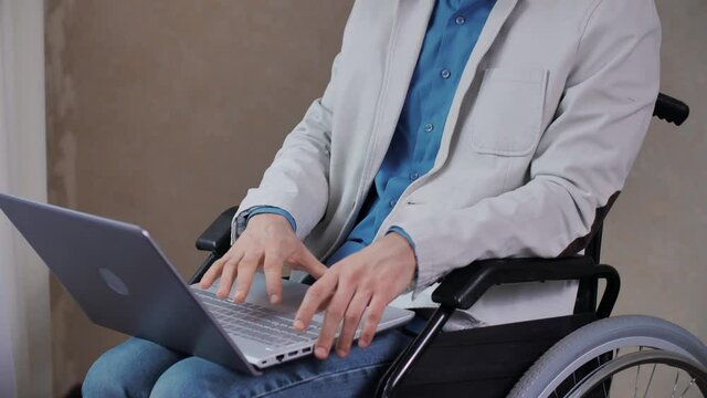 Disabled man in wheelchair working on laptop
