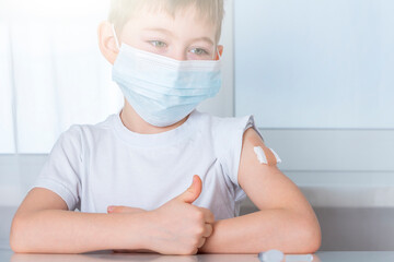 Vaccination and immunization of population concept. Kid boy in protective medical mask with plaster...