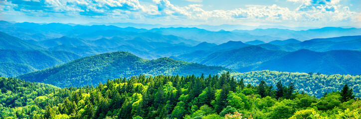 Panele Szklane  Panoramiczny widok na Smoky Mountains z Blue Ridge Parkway w Północnej Karolinie. Błękitne niebo z chmurami nad warstwami zielonych wzgórz i gór. Karolina Północna. Obraz banera i nagłówka internetowego.