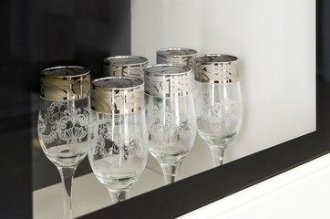Beautiful glass wine glasses are on the shelf.