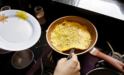 Preparing an omelet with zucchini and cheese. Homemade and organic food.  Photo focus in the center of the frying pan. Soft focus.