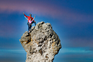 Two male and female climbers on top of a rocky peak