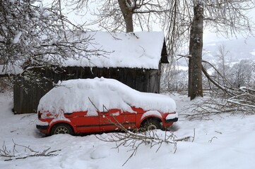 red car in the snow in winter