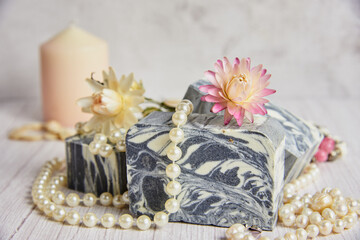 Gray-white handmade soap made from natural ingredients is decorated with pearl beads.