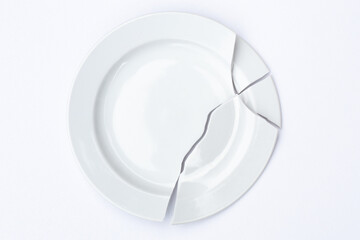 shards of a broken white plate stacked together on a white background. The concept of breaking up...