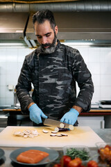 Professional military base chef or cook preparing delicious tasty meal with fresh salmon fish and salad.