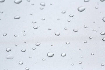 Drops in row on metal surface with shallow depth of field