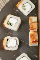 Tasty dragon sushi rolls with eel on black plate