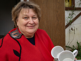 The cheerful mature woman in red smiled at the photographer.