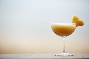 Glass of pinacolada cocktail standing on the wood table.