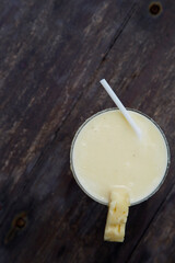 Glass of pinacolada cocktail standing on the wood table.