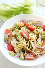 Pasta salad with tomato, avocado, chiken and red onions