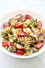 Pasta salad with tomato, avocado, chiken and red onions