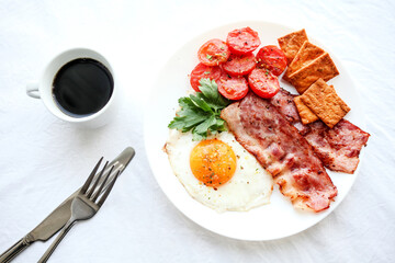 English breakfast - fried eggs, herbs, tomatoes, bacon and crackers
