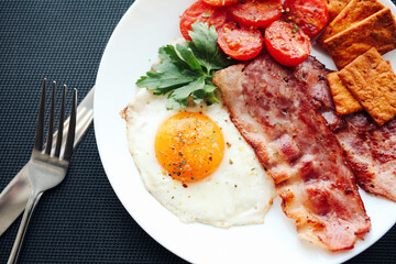 English breakfast - fried eggs, tomatoes, bacon and crackers
