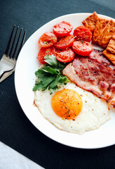 English breakfast - fried eggs, herbs, tomatoes, bacon and crackers