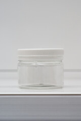 transparent container with a screw cap for storing cosmetic products