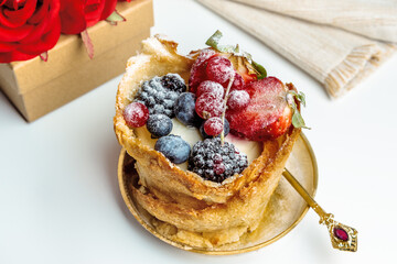 French dessert from bakery on white table with gift box and red roses on background. selective focus