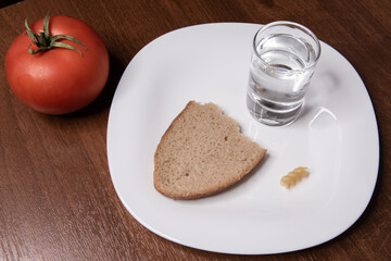bread, pasta and vodka with tomato on a white plate on a wooden background
