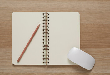 Blank Spiral Note Pad, computer mouse and Pencil on Wood Background.