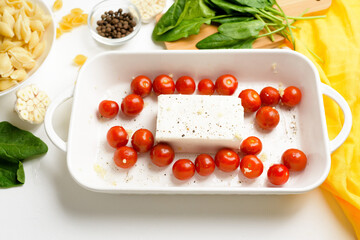 step-by-step preparation and ingredients for oven-baked feta cheese with tomatoes and pasta, pepper garlic on a light background top view, trend recipe