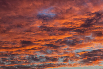 Background photo of dark blue sky in the evening with  orange and red shade of the sunset. Beautiful and natural clouds formation.