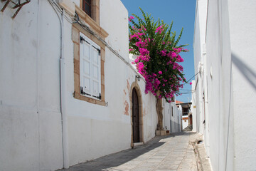 Fototapeta na wymiar Beautiful empty street at Lindos, Rhodes, Dodecanese, Greece on a sunny day