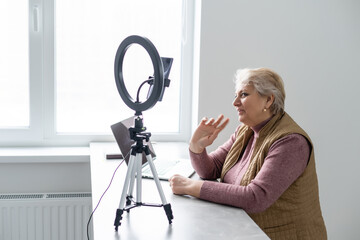 Profile side view portrait of her she nice attractive addicted focused gray-haired blonde granny playing network web virtual team game at industrial loft modern concrete style interior house flat