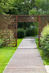 Road in the garden. Walk in the park. The bridge path in the park. Openwork arch, gazebo in the park.