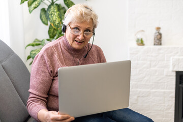 The elderly woman writes on the computer