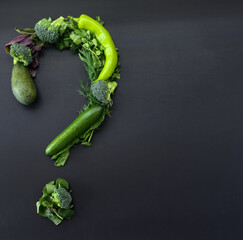 Green vegetables question mark on black background with copy space