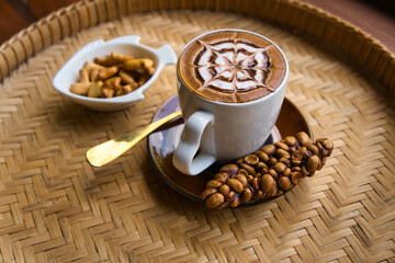 Fresh coffee in civet glass placed on a rattan tray