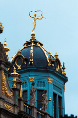 Escultura dorada en lo alto de un edificio belga