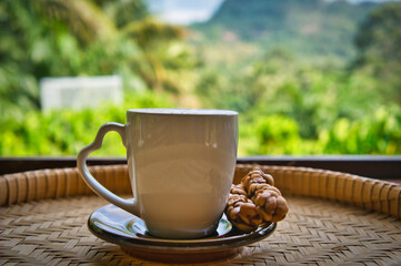 Civet coffee cup placed on rattan Mountain and sky background