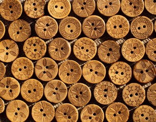 Variety of ethnic tribal African boho brown coconut buttons on brown rustic linen fabric. A pattern...