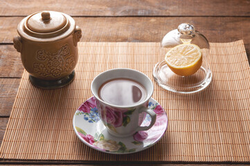 table setting, cup of tea with glass lemongrass on a wooden table