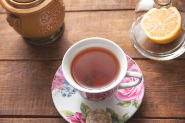 table setting, cup of tea with glass lemongrass on a wooden table
