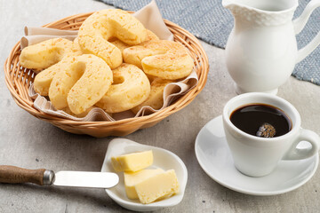 Chipas, typical south american cheese bun in a basket with butter and coffee